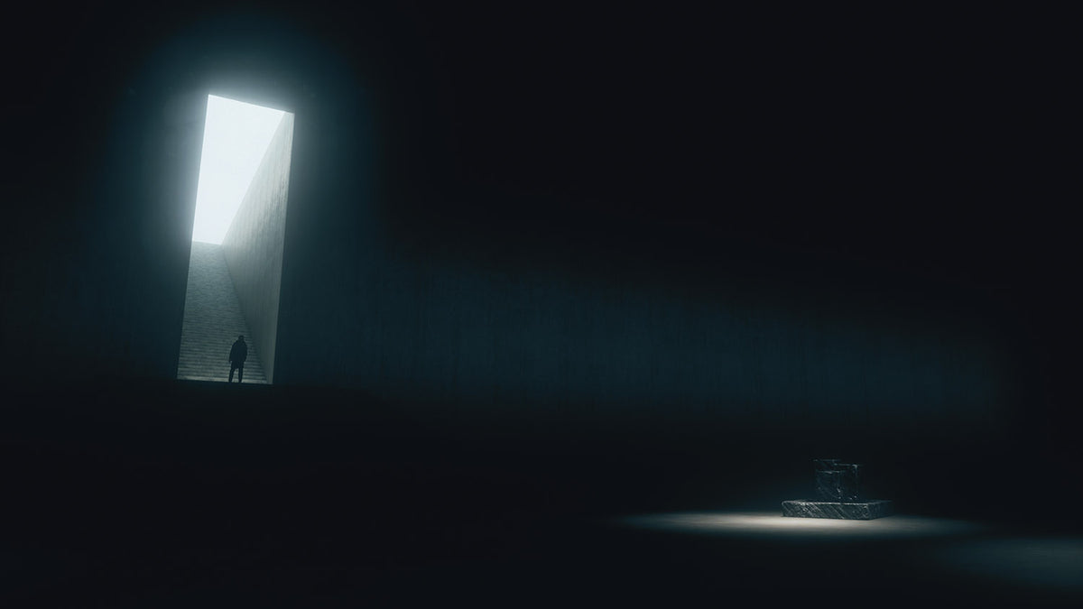 Person standing in a dark room with a light shaft coming through a rectangular opening.