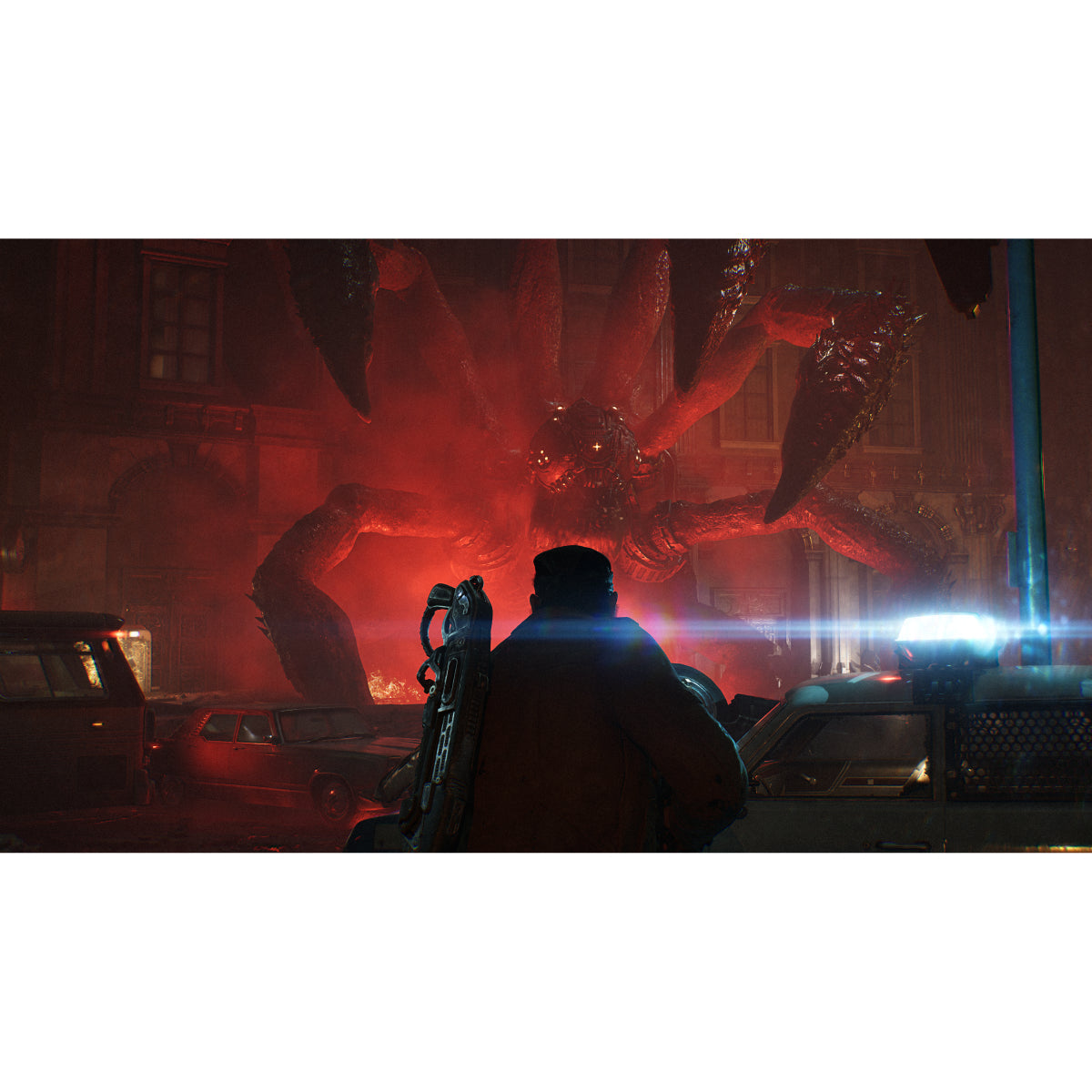 A dramatic cinematic scene showing a person from behind holding a chainsaw-like weapon in a dark street at night, with a large red monster looming in the background among parked cars and glowing red light.